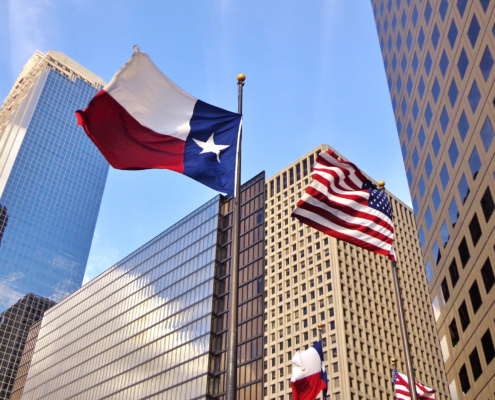 Low angle view of United States of America flag and Texas state flag